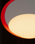Close-up of walnut table lamp with red inner ring and soft warm glow